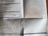 un ticket de caisse posé sur une table, avec la photo d'une voiture dessus