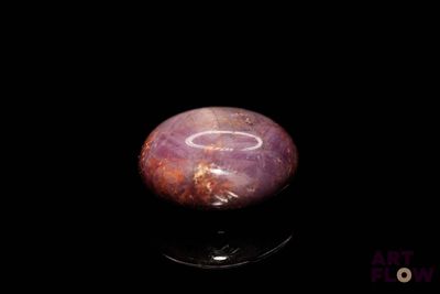 an image of a purple stone on a black surface