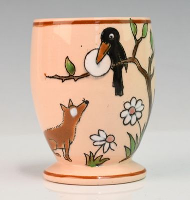 une petite tasse sur laquelle sont représentés un oiseau et un chien