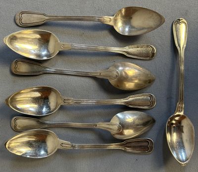 five spoons that are sitting on a table