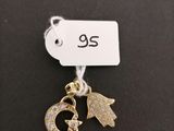 a close up of a gold charm with a cat on it