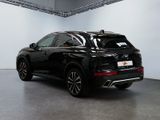 the rear end of a black suv parked in a garage