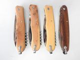 four different types of knives are lined up on a white surface