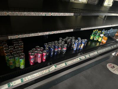 de nombreuses canettes de soda sur les rayons du magasin