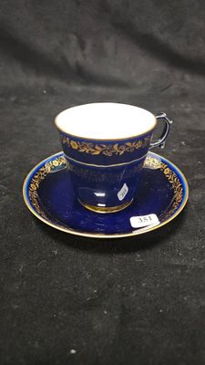 un gros plan d'une tasse et d'une soucoupe posées sur une surface noire