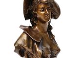 bronze bust of a woman with a hat on her head