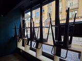 many umbrellas hanging on the windowsill of a restaurant