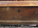 an old wooden chest sitting on top of a rug in a room