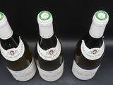 trois bouteilles de vin posées sur une table l'une à côté de l'autre