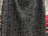 a black and white tweed skirt hanging on a rack