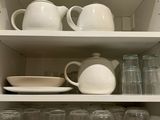 a white shelf with a lot of dishes and cups on it