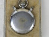 a silver pocket watch in a box on a white surface