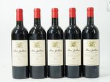 quatre bouteilles de vin sont alignées sur une surface blanche