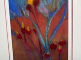 tableau représentant un tableau de fleurs dans un cadre blanc posé sur une table