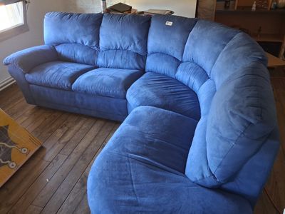 a blue couch in a living room with a wooden floor