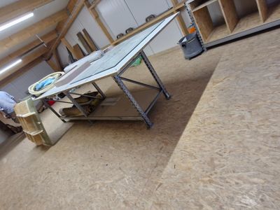 un homme qui travaille sur une table dans une pièce