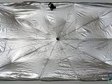 un parapluie argenté avec un manche noir posé sur une table