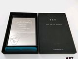 a silver lighter in a black box on a white table