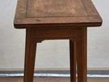 a small table with a wooden top on a hard wood floor
