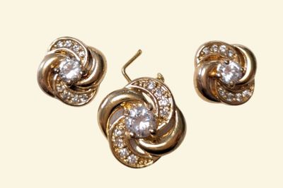three pieces of jewelry are shown on a white surface
