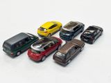 several toy cars are lined up in a row on a white surface