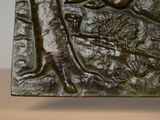 a bronze sculpture of a bird on a tree