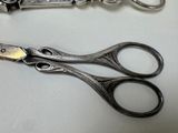 two pairs of scissors sitting on a table next to each other