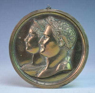 une pièce de bronze sur laquelle figurent une femme et un homme