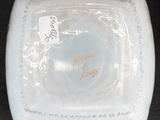 a white bowl with a label on it on a black surface