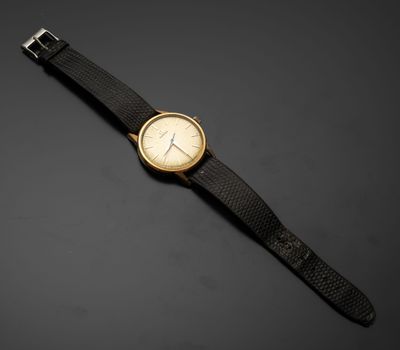 une montre dorée et noire posée sur une surface noire
