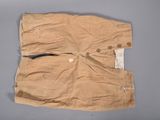 un vieux pantalon avec des boutons, posé sur une surface grise