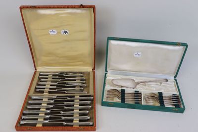 deux sets d'argenterie dans un coffret sur une table