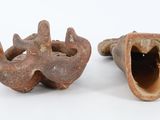 two pieces of pottery are sitting next to each other on a white surface