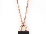 a gold chain with a black purse on it
