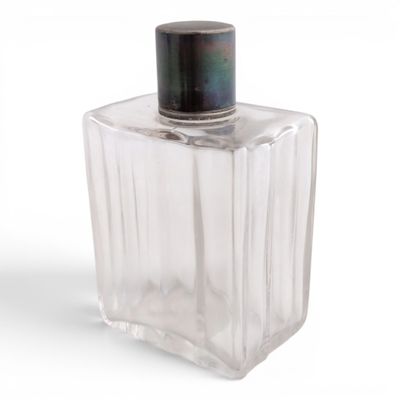 a clear glass bottle with a black top