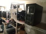 a desk with a computer and a fan in a room