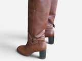 pair of women ' s brown boots with white socks and black leggings
