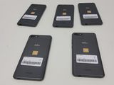 four cell phones are sitting next to each other on a table