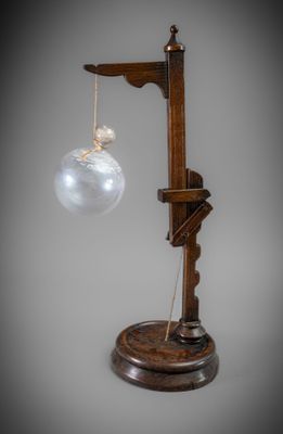 une lampe à l'ancienne dont le bras est orné d'une boule en verre