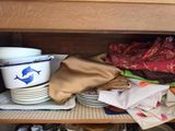 many plates and bowls on a shelf in the kitchen