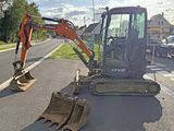 a small excavator that is sitting on the side of the road
