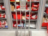 un chariot métallique au milieu d'une pièce remplie de bacs rouges