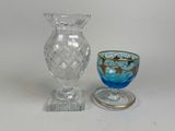un petit vase en verre et une petite tasse en verre posés sur une table