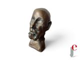 une image représentant une sculpture en bronze représentant la tête d'un homme, sur fond blanc