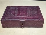 purple leather box with decorative design on top of it on a table