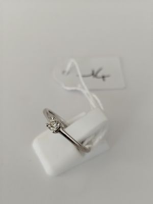 a close up of a ring on a white surface with a tag