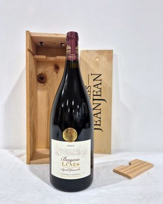 a bottle of wine that is sitting next to a wooden box