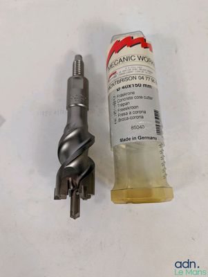 une image montrant un gros plan d'une bouteille contenant un liquide, à côté d'une perceuse