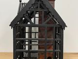 a small black building with a chimney on top of it