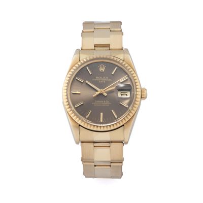 une photo d'une montre-bracelet en or avec un cadran gris
